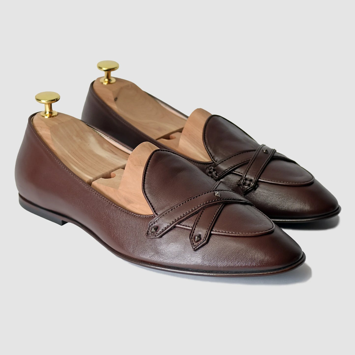 Chestnut brown Italian leather Lincoln saddle loafers by JB Ander, front three-quarter angle showing double cross-strap detail, antiqued gold metal accents, and leather outsole edge.