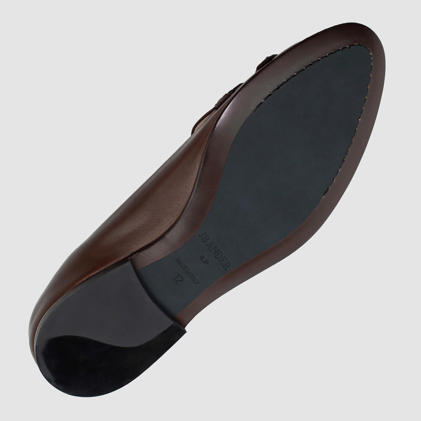 Leather sole of the JB Ander Lincoln saddle loafer in Chelsea brown, showing polished brown leather edge, 'Made in Italy' detail, and slim rubber heel for comfort and grip.