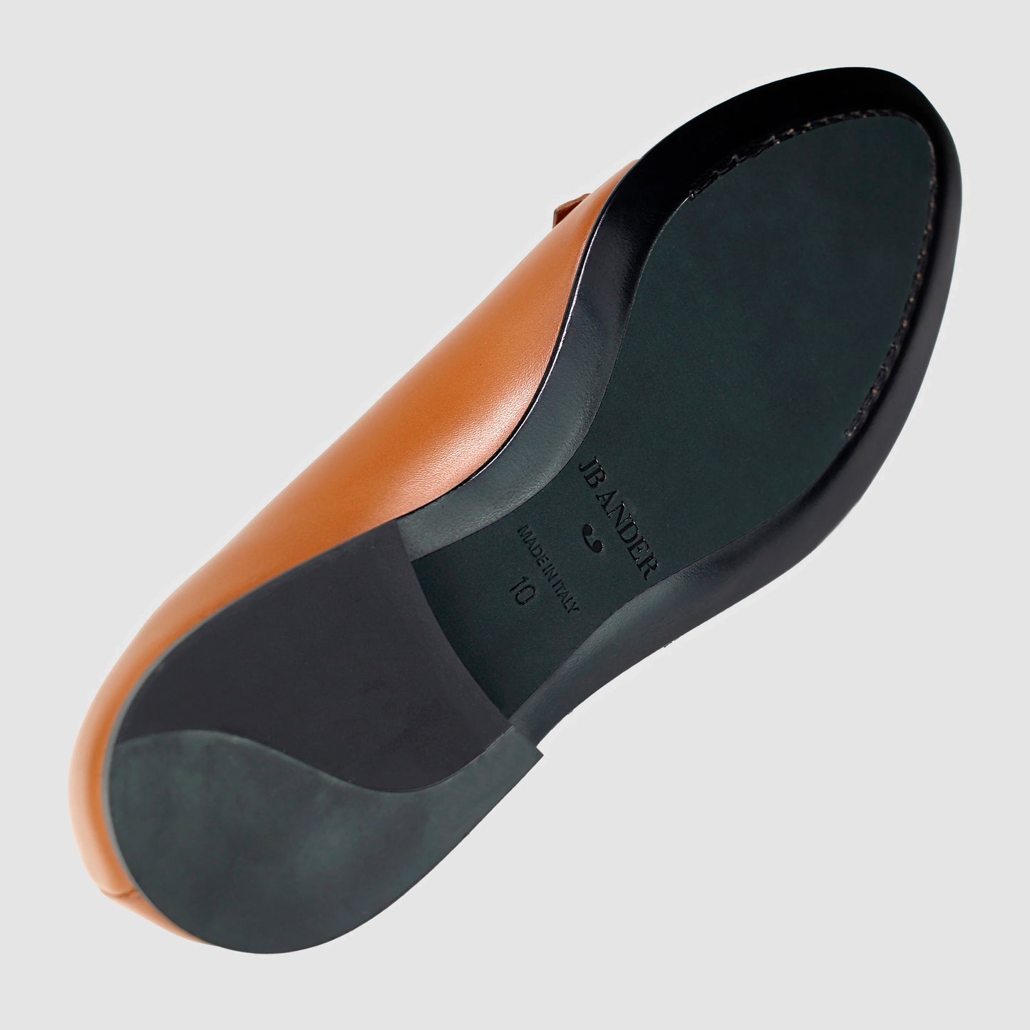 Leather sole of the JB Ander Lincoln saddle loafer in Terracotta luxury leather, showing polished black leather edge, 'Made in Italy' detail, and slim rubber heel for comfort and grip.