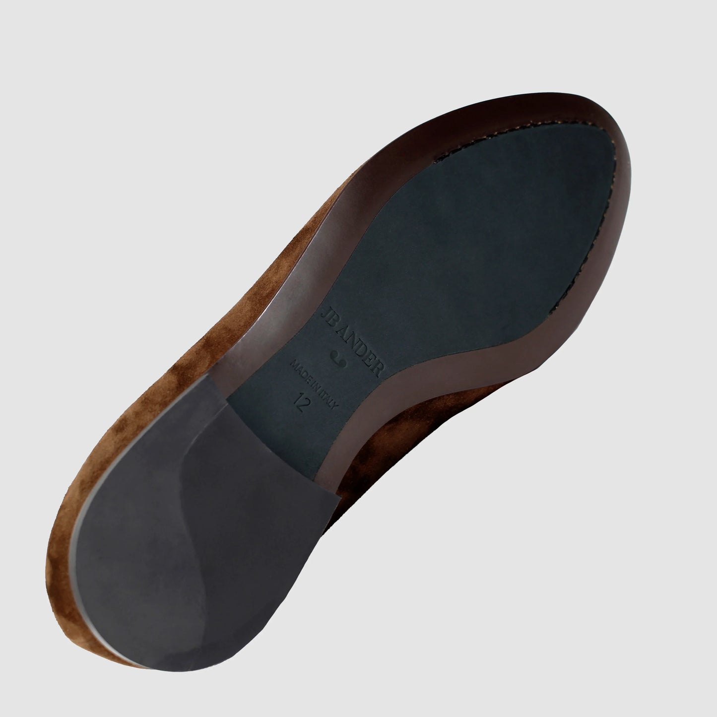 Leather sole of the JB Ander Valedictorian tassel loafers in Park Ave Pecan brown suede, showing polished brown leather edge, 'Made in Italy' detail, and slim rubber heel for comfort and grip.