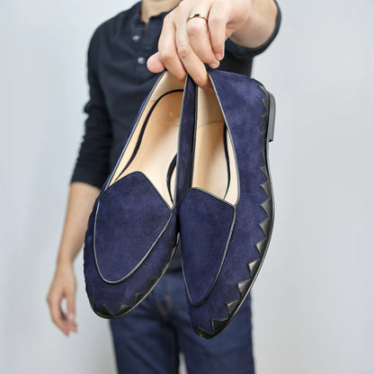 Model holding JB Ander men's Great White smoking slipper loafers in Marino navy suede with unique leather trim, and handmade Italian craftsmanship.
