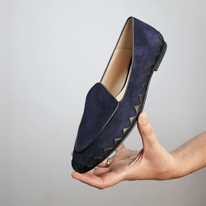 Model holding JB Ander men's Great White smoking slipper loafers in Marino navy suede with unique leather trim, and handmade Italian craftsmanship.