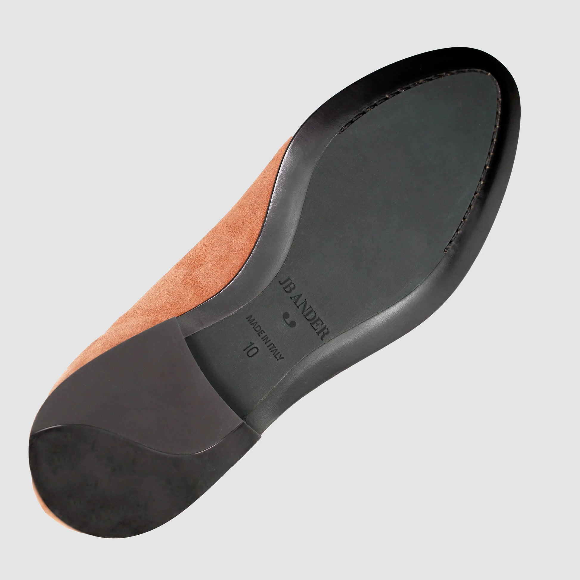 Leather sole of the JB Ander Valedictorian tassel loafers in Terracotta color suede, showing polished black leather edge, 'Made in Italy' detail, and slim rubber heel for comfort and grip.