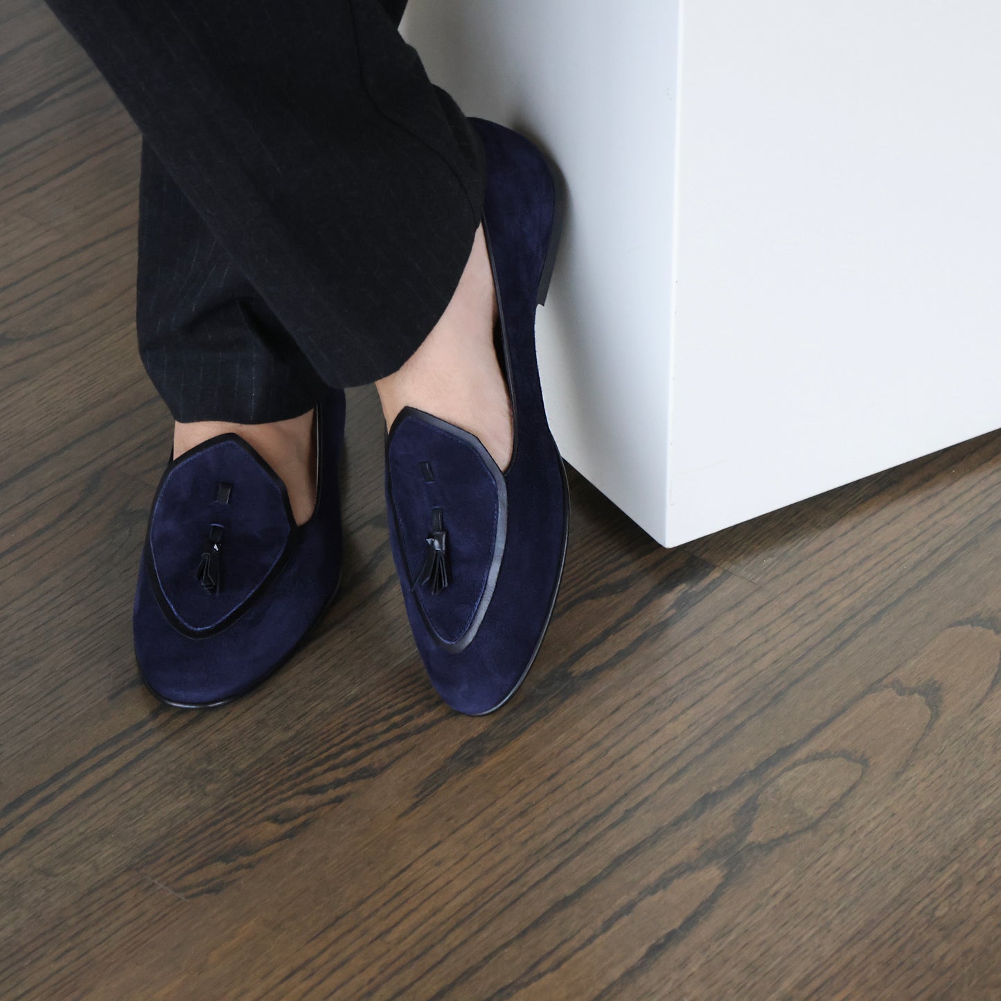 Model wearing JB Ander men's Valedictorian tassel loafers in Marino navy suede with black leather trim, and handmade Italian craftsmanship.