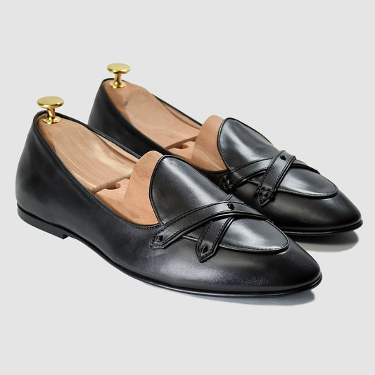 Black Italian leather Lincoln saddle loafers by JB Ander, front three-quarter angle showing double cross-strap detail, wooden cedar shoe trees, and leather outsole edge.