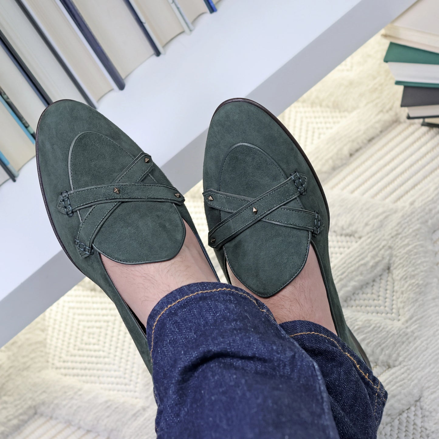 Emerald green suede saddle loafers with leather straps worn with blue jeans