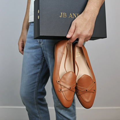 Model holding JB Ander's Lincoln saddle loafer in terracotta Italian leather – handcrafted in Italy with dual straps on vamp, and luxurious calfskin insole.